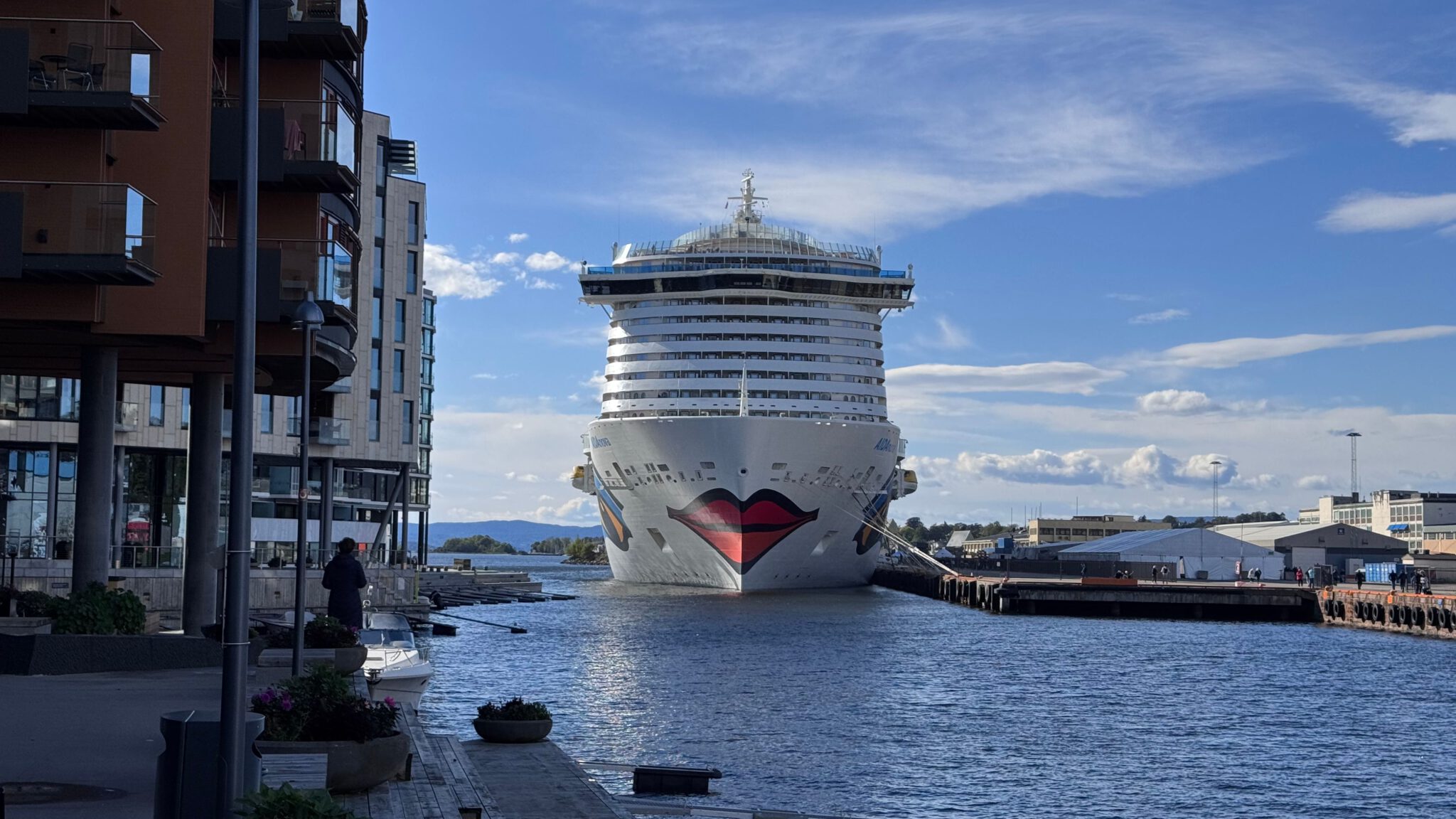 Oslo Ein AIDA-Kreuzfahrtschiff liegt an einem Kai in Oslo, links stehen moderne Wohnhäuser an der Uferpromenade