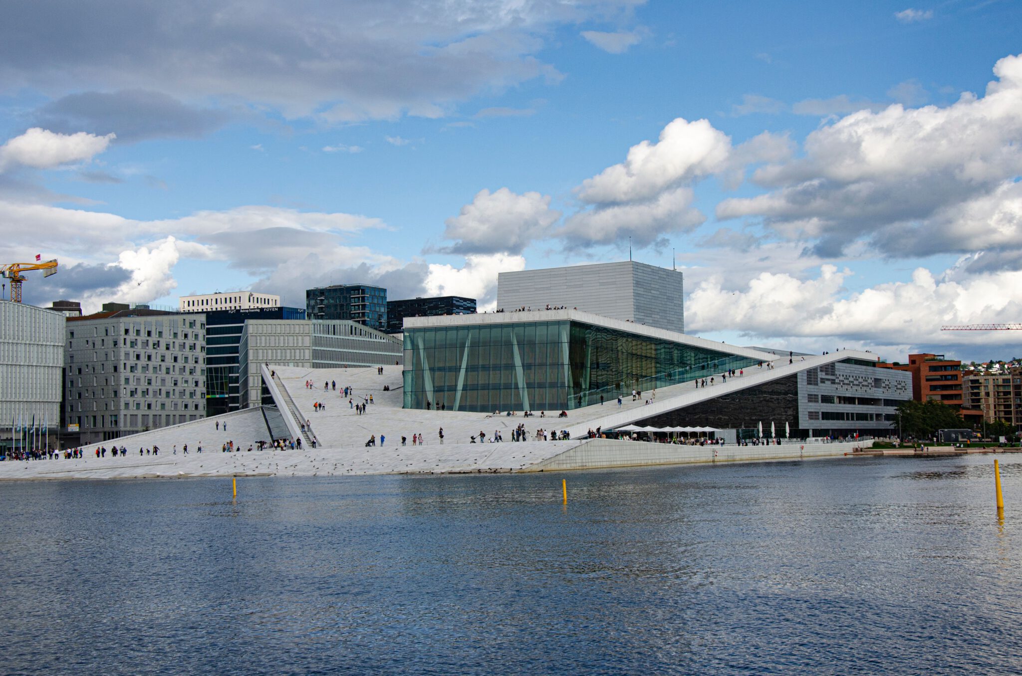 Oslo Das Opernhaus von Oslo aus weißem Marmor und Glas am Fjord, auf dem schrägen Dach gehen viele Besucher